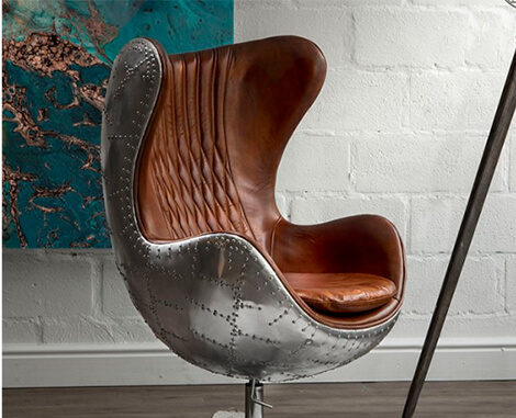Side angle of leather and stainless steel Egg Chair in office setting